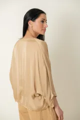 Blusa italiana de viscosa color beige, con escote en V ribeteado con lurex, mangas tres cuartos amplias y calce holgado.