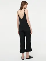 Mono largo negro de viscosa con breteles finos regulables y tejido arrugado.