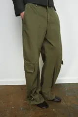 Pantalón cargo de tiro medio confeccionado en algodón, con diseño de pierna ancha y costuras verticales. Presenta bolsillos laterales y bolsillos de plastrón con solapa en las piernas. El bajo es ajustable mediante trabillas y hebillas metálicas.