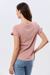 Remera de algodón color verde menta, con escote redondo y mangas corta con detalles de volados sutiles en los puños.
