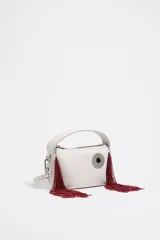 Bolso bandolera blanco de piel, tamaño mini, con cierre de cremallera y asa de piel. Exterior personalizado con Logo Chimo esmaltado y detalle de flecos de cuentas rojas. Contiene poliéster reciclado.