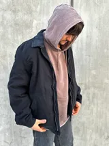 Campera negra con cierre frontal, cuello camisero y bolsillos laterales.