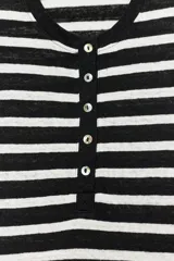 Camiseta de manga corta con diseño a rayas horizontales en blanco y negro, cuello redondo y cartera con botones frontales.