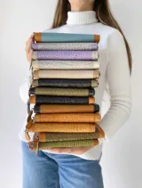 Billetera grande con cierre metálico, color beige. Presenta un panel central con textura tejida o tramada en tono claro y bordes de cuero liso en tono beige más oscuro. Posee un parche de cuero con la palabra "chouie" escrita a mano.