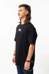 Remera negra de algodón con estampado en la espalda que dice "THE EARTH IS FLAT" y un dibujo de un hombre con micrófono parado sobre una tierra plana.