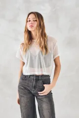 Remera corta de tul blanco, de corte holgado y mangas cortas.