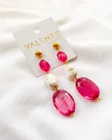 Aros colgantes con cuentas de vidrio facetado color fucsia, cuentas de piedra blanca con manchas marrones y detalles dorados.