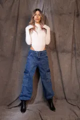 Pantalón cargo de denim azul con calce holgado, tiro medio, bolsillos laterales con solapa y elásticos ajustables en cintura y tobillos.