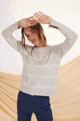 Sweater lila con rayas horizontales color crudo, de corte holgado y cuello redondo.
