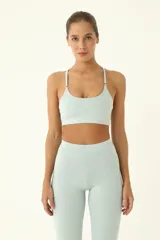 Top deportivo celeste de compresión media, con elástico invisible y tiras delgadas.