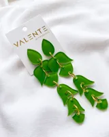 Aros colgantes largos de acrílico verde con forma de hojas unidas por argollas doradas.