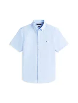 Camisa de manga corta Tommy Hilfiger en color celeste, confeccionada en tejido de popelina con tecnología flex. Presenta cuello clásico, cierre frontal con botones y el logo de la marca bordado en el pecho.