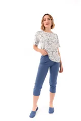 Conjunto de pijama de algodón color champagne, compuesto por una remera de manga corta con cuello henley y bolsillo en el pecho, y un pantalón capri a rayas horizontales celestes y blancas.