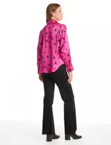 Camisa de satén con estampado de rectángulos negros sobre fondo blanco. Presenta cuello con solapa, cierre frontal con botones metálicos y mangas largas con puños clásicos.