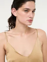 Top de tirantes finos con escote en V, confeccionado en tela satinada con caída fluida.