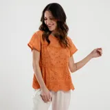 Blusa color naranja con cuello redondo, mangas cortas y detalle de bordado calado.