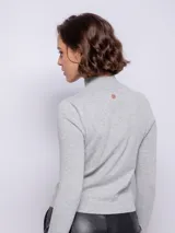 Polera color crema de tejido de punto, manga larga y cuello alto.