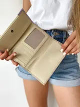 Billetera de cuero color camel con solapa verde lima y detalles en color crema. Tiene cierre con broche y monedero externo.