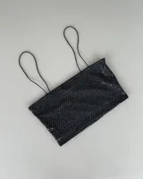 Top negro con lentejuelas y tirantes finos.