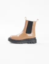 Bota Chelsea color caramelo de cuero sintético con elástico negro en los laterales y suela track negra.