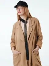 Blazer color marrón claro, de corte holgado, con solapas y bolsillos delanteros.
