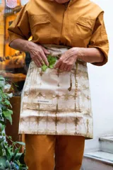 Delantal corto de algodón color crudo con teñido artesanal shibori en tonos marrones.