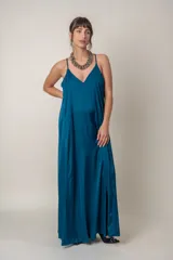 Vestido largo de seda en color azul petróleo, con escote en V, breteles finos y bolsillos laterales. Diseño holgado y fluido.