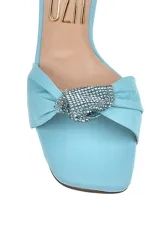 Sandalia de tacón alto color amarillo con pulsera al tobillo y detalle de moño con strass en la capellada.