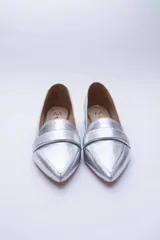 Mocasines negros de cuero con punta fina y detalle de antifaz.