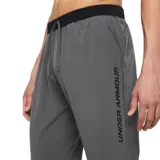 Pantalón de running gris con tecnología UA Storm que repele el agua, tejido elástico y resistente al viento. Cuenta con cintura de punto suave con cordón interior, bolsillos laterales y cremalleras en los tobillos.