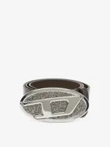 Cinturón de cuero bovino marrón con hebilla ovalada grande de metal plateado. La hebilla tiene un diseño con la letra 'D' en el centro, y el fondo está cubierto de pequeñas piedras brillantes.