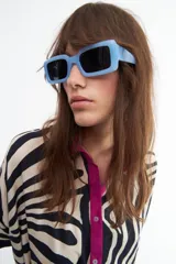 Lentes de sol con montura rectangular celeste y cristales negros. Cuentan con filtro de protección UV 400 que bloquea los rayos UVA y UVB.