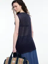 Musculosa de tejido fino y translúcido con sutil brillo metálico, de corte relajado, sin mangas y largo por debajo de la cadera con aberturas laterales.