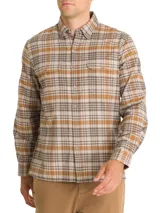 Camisa de franela de algodón orgánico para hombre, de manga larga y calce regular, con estampado de cuadros en tonos marrón, beige y tostado. Cuenta con cuello camisero, cierre frontal con botones de madera y dos bolsillos frontales con solapa.