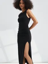 Vestido midi negro sin mangas, de corte ajustado con frunces laterales y abertura alta en la pierna.