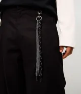 Pantalón masculino de sarga de algodón en color negro, con corte baggy balloon de piernas amplias y leve ajuste en los puños. Diseño de acabado liso, con amplios bolsillos delanteros y llavero removible en la cintura.