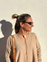 Buzo de tejido de punto color beige, de corte holgado y mangas largas.