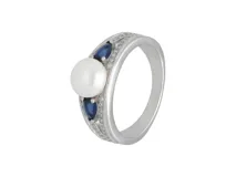 Anillo de plata 925 con una perla central, acompañado de circonias azules en forma de lágrima y pequeños cristales brillantes engastados en los laterales.