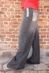 Jean de corte wide leg con diseño de paneles en diferentes tonos de gris y negro. Presenta cierre frontal expuesto y costuras decorativas que crean un efecto visual de bloques de color.
