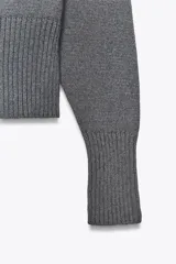 Jersey de punto con cuello barco y manga larga, con acabados en rib en cuello, puños y ruedo.