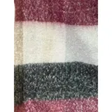 Bufanda rectangular de tejido grueso con diseño de cuadros en tonos azul, naranja, gris y beige, terminada con flecos en los extremos.