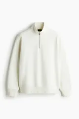 Buzo en tejido pesado de mezcla de algodón con cuello elevado y medio cierre frontal. Modelo de corte holgado con hombros caídos, puños y bajo en punto acanalado.