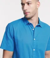 Camisa de manga corta de lino y algodón color beige, de corte confort, con cuello camisero y cierre frontal de botones.