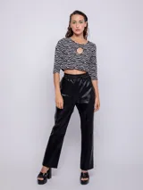 Top corto negro con estampado de líneas onduladas blancas, mangas 3/4 y abertura circular en el pecho.