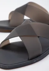 Sandalia chata de goma semi transparente color gris, con doble tira entrelazada sobre el empeine.