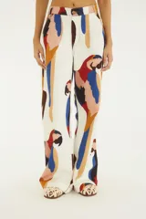 Pantalón ancho de tiro alto confeccionado en algodón, con estampado colorido de loros, bolsillos funcionales y cierre frontal con botón y cremallera.