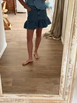 Minifalda de denim con volados en el borde inferior y bolsillos delanteros.