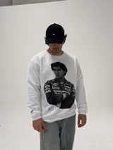 Buzo de cuello redondo color blanco, con estampa fotográfica frontal de Ayrton Senna con su traje de piloto de Fórmula 1.