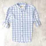 Camisa de algodón a cuadros celestes y blancos, con cuello mao, manga larga y puños abotonados.