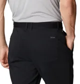 Pantalón técnico de senderismo color negro, con cintura elástica parcial, bolsillos laterales y bolsillo de seguridad con cierre. Cuenta con tecnología de repelencia al agua y protección solar.
